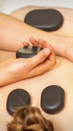 masseur holding black massage stones spa salon